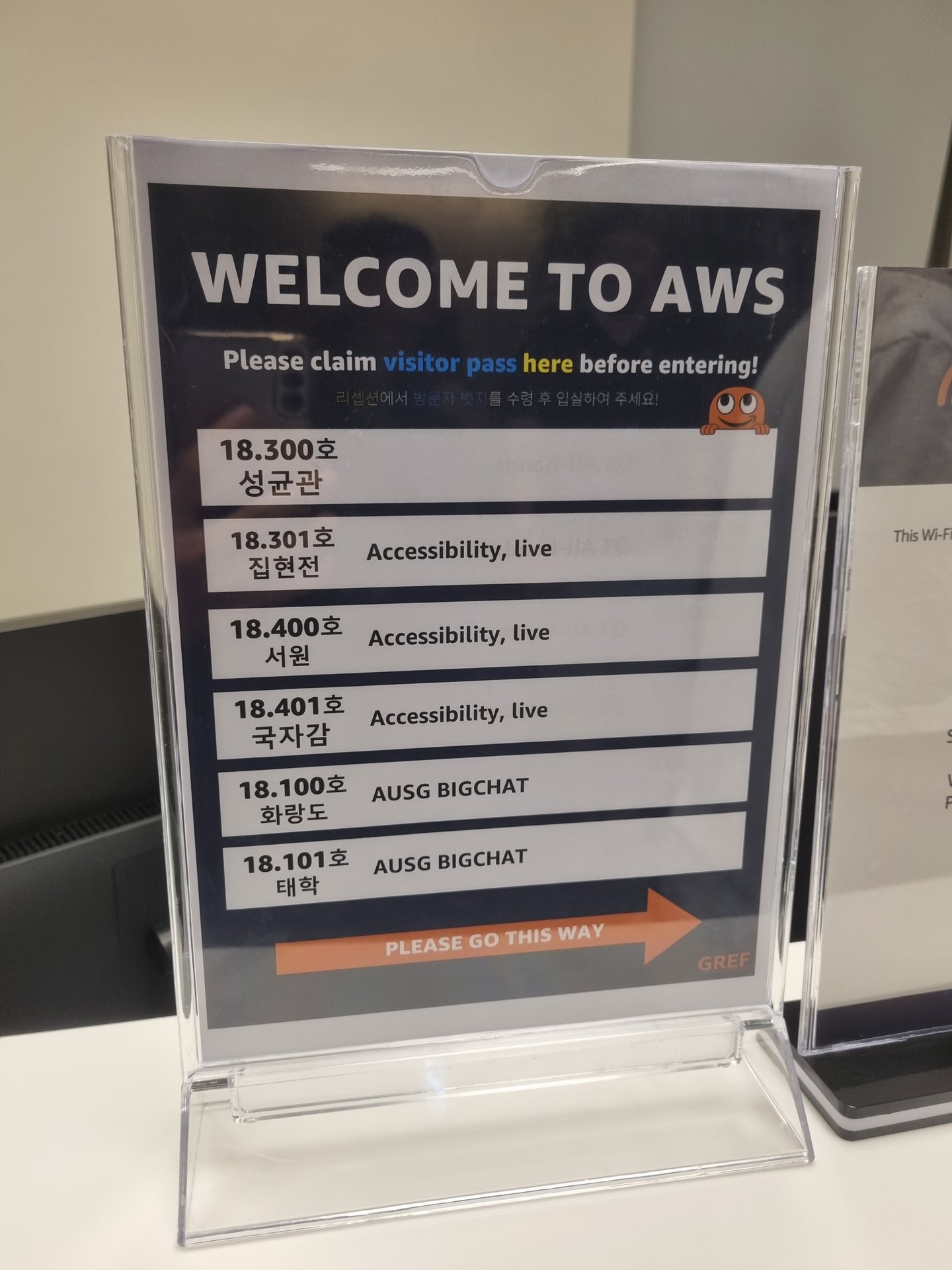 AWS 방문 안내판에 Accessibility, live 행사 이름과 행사장 위치가 적혀 있다.
